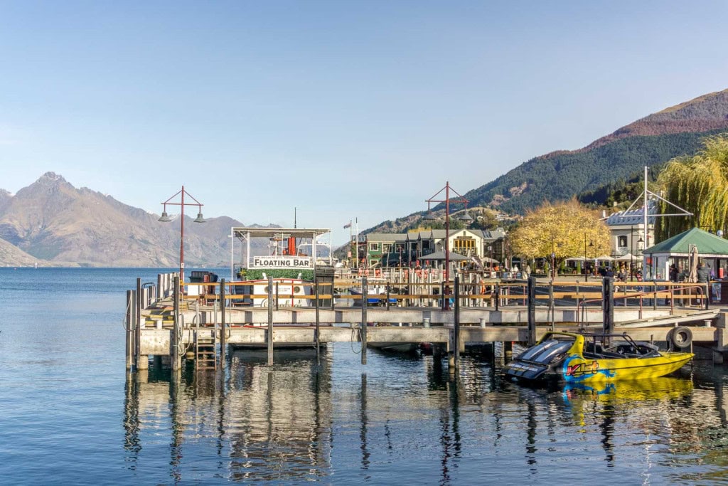 The wharf at Queenstown Bay with the Kjet Jetboat and Perky's Floating Bar on the water.