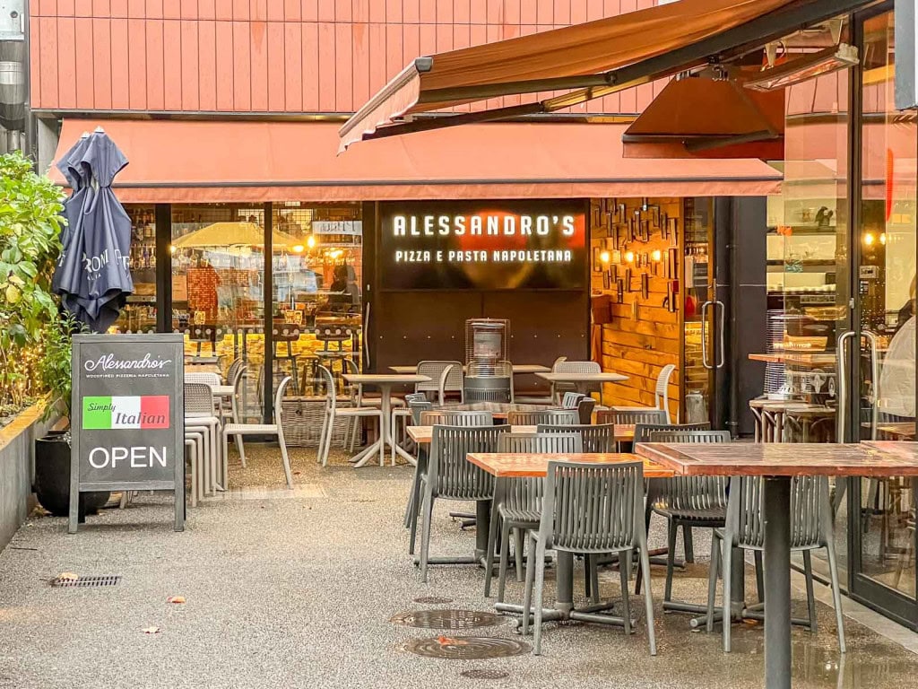 The entrance to Alessandro's, a pizza and pasta restaurant in Havelock North, Hawkes Bay, with tables set up in the outdoor courtyard.