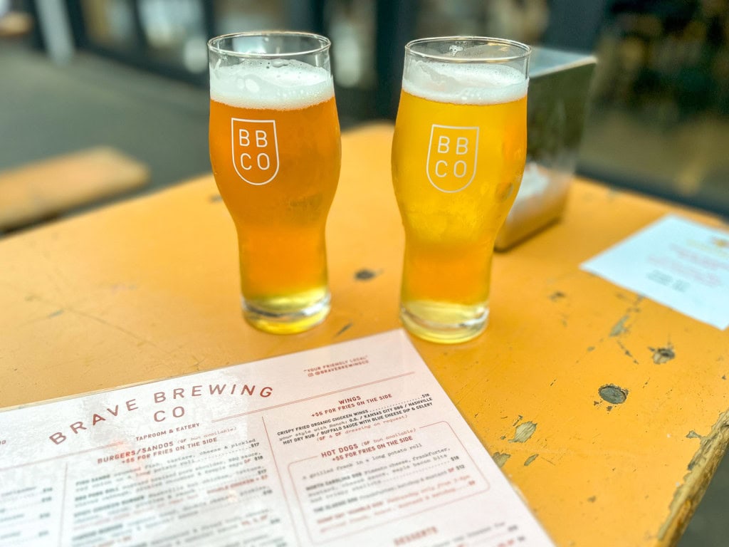 Two pints of beer on a wooden table at Brave Brewing Co in Hastings.