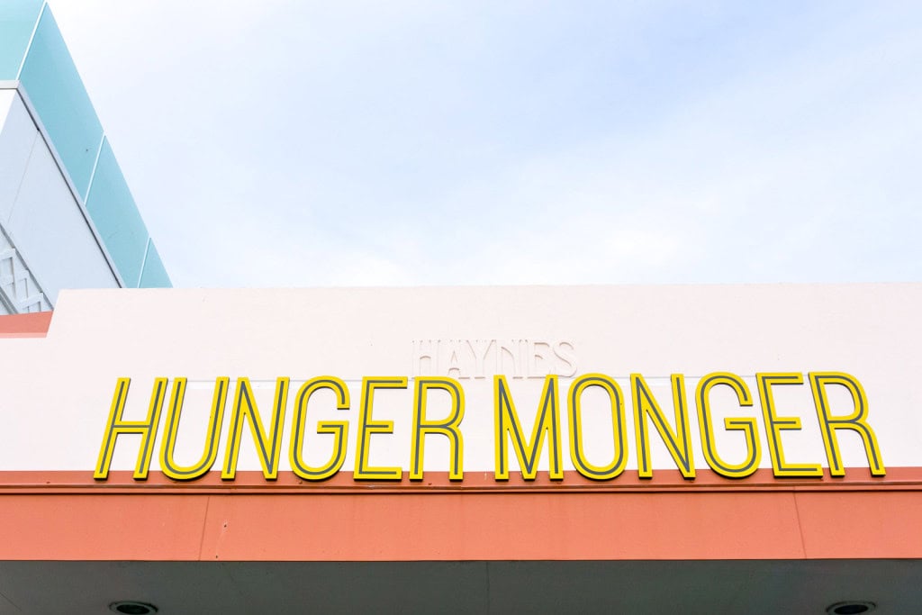 Signage at the entrance to Hunger Monger restaurant in Napier, with yellow lettering above an orange awning.
