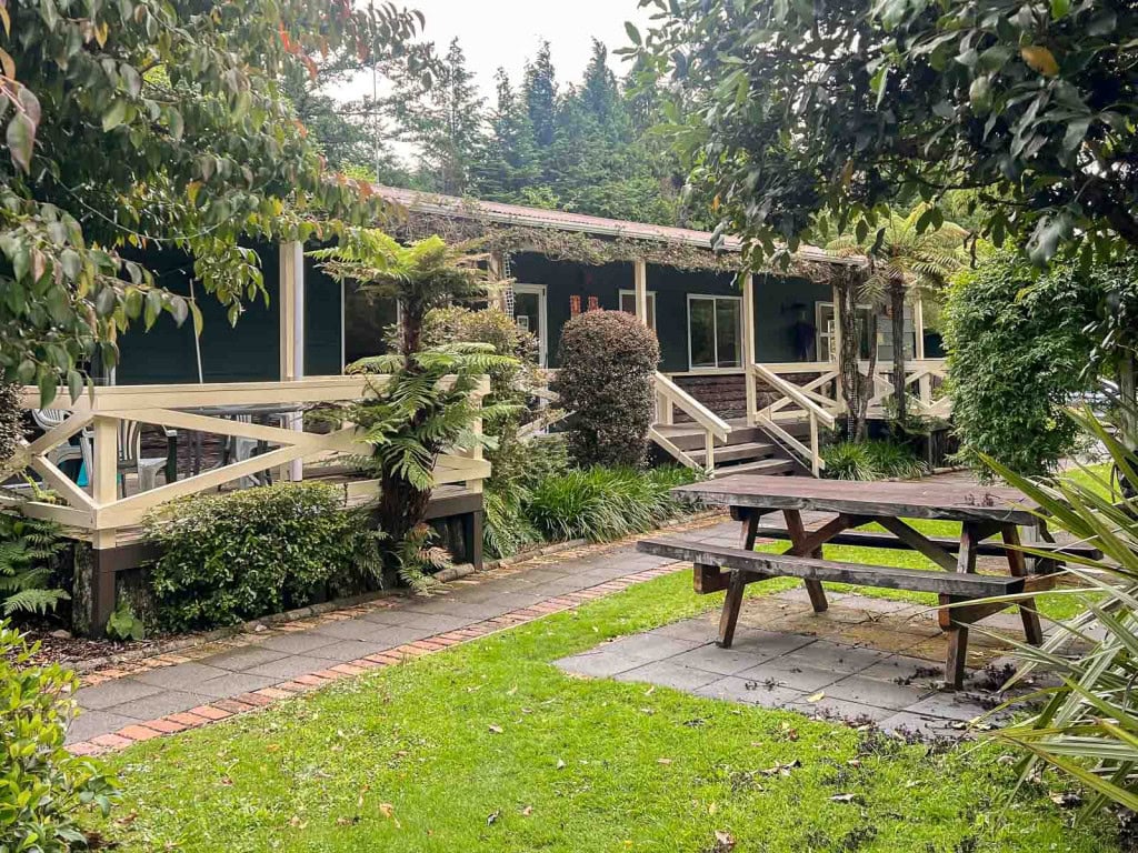 Lodge rooms surrounded by gardens with a picnic table out front at Creel Lodge in Turangi, a great place to stay near Tongariro National Park.