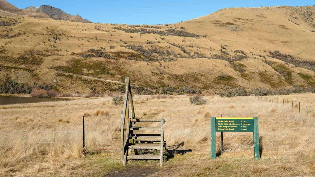 A trail sign and stile on the Moke Lake Loop Track.